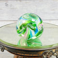 Multicolor glass paperweight with green white pink and blue swirls