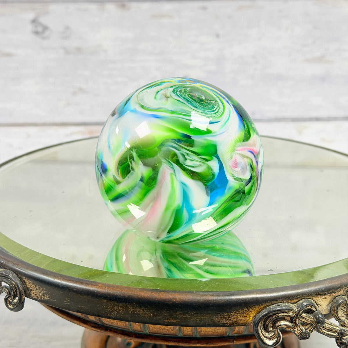 Multicolor glass paperweight with green white pink and blue swirls