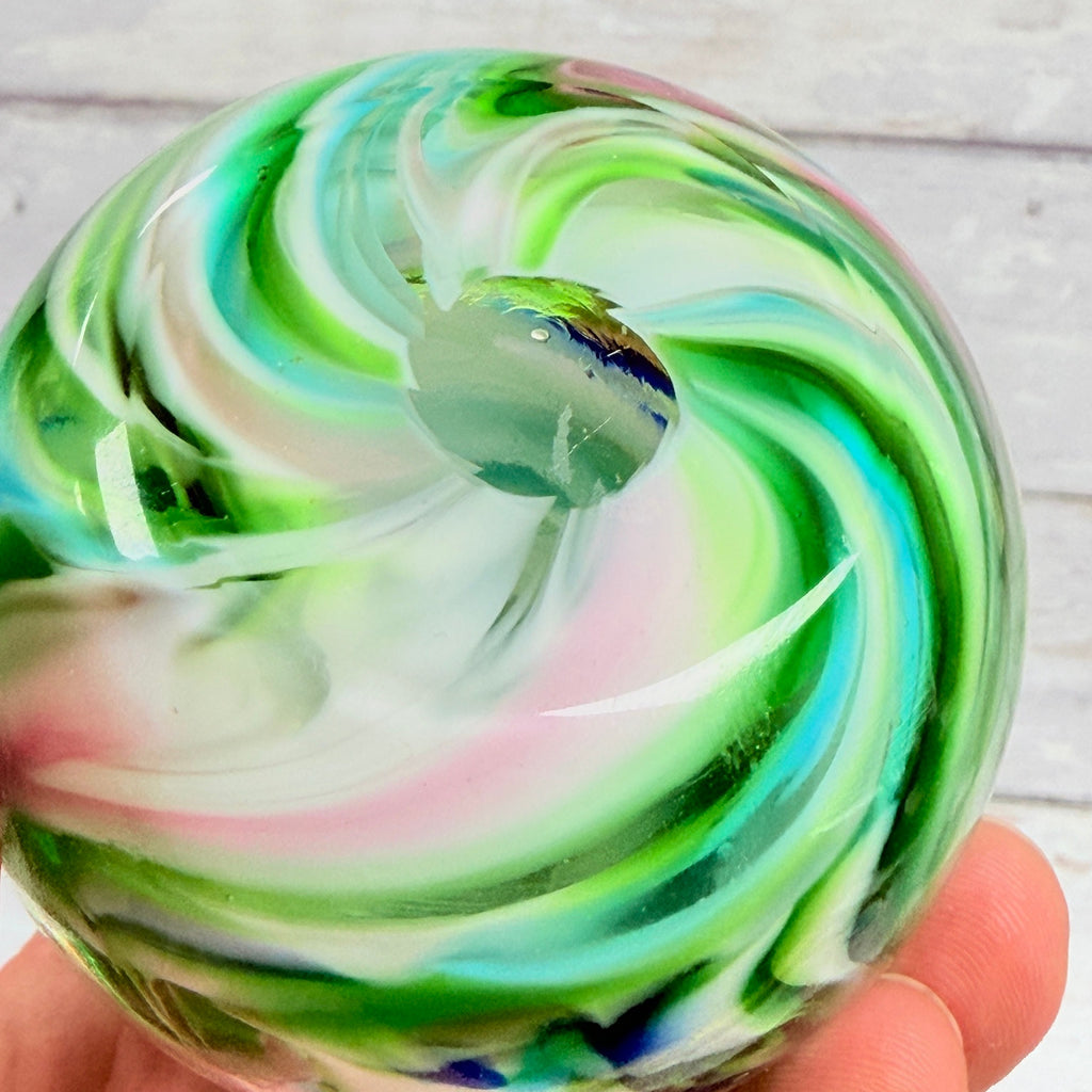 Underside of multicolor swirl paperweight showing circular pontil area