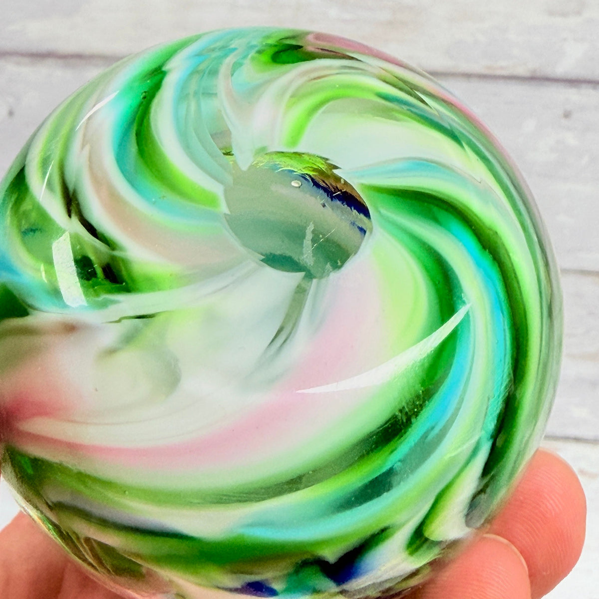 Underside of multicolor swirl paperweight showing circular pontil area