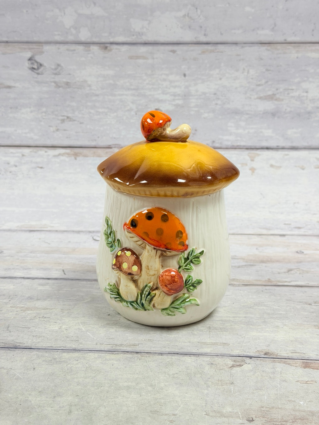 Merry Mushroom ceramic canister with gold and brown lid and raised mushrooms