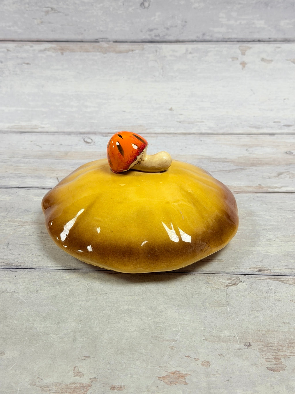 Gold and brown Merry Mushroom lid with orange mushroom finial