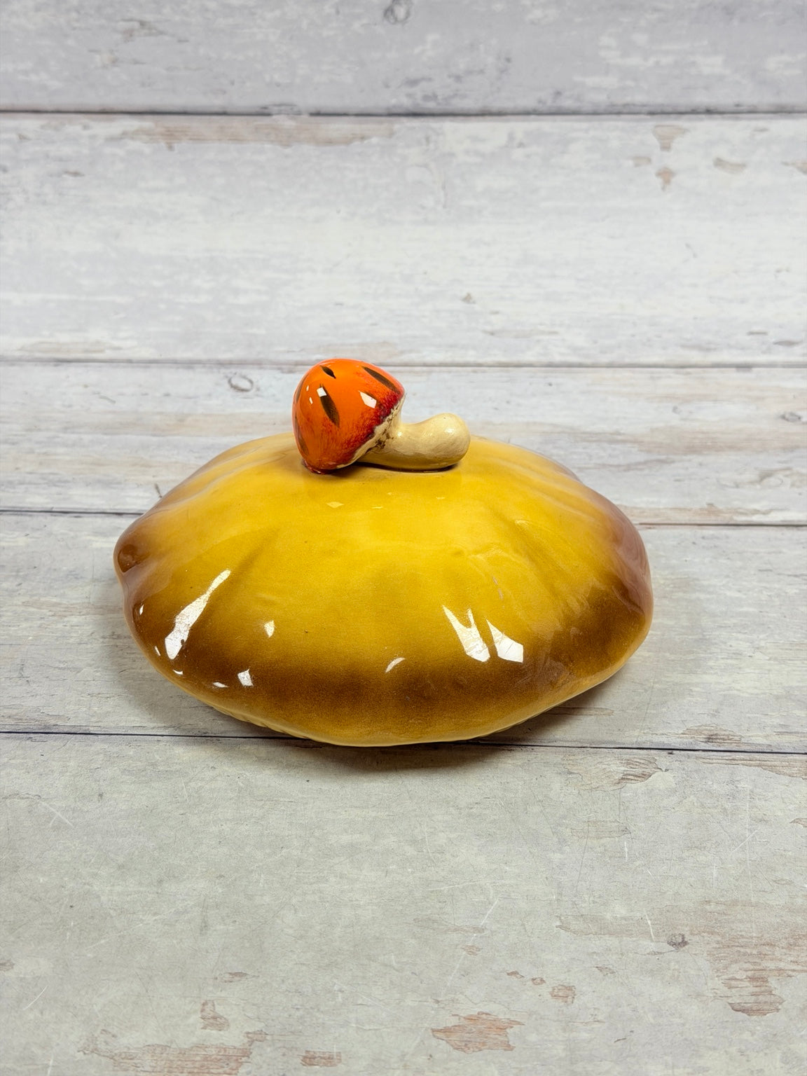 Gold and brown Merry Mushroom lid with orange mushroom finial