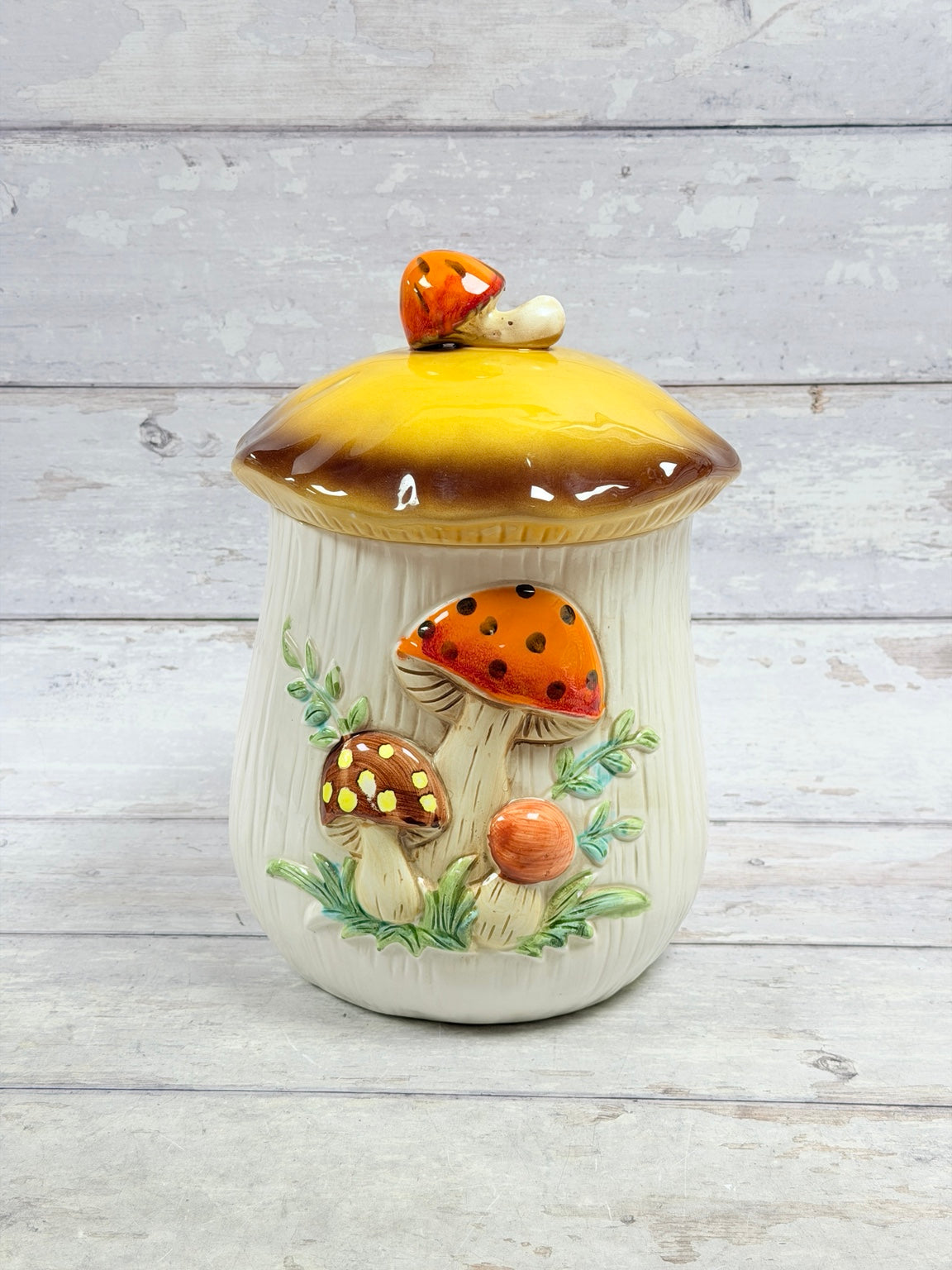 Mushroom ceramic canister with yellow and brown cap and mushroom finial, front view