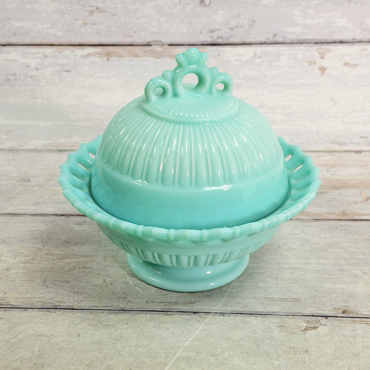 Fostoria Randolph aqua blue milk glass covered candy dish, front view showing pierced lace rim, ribbed dome lid and pedestal base.