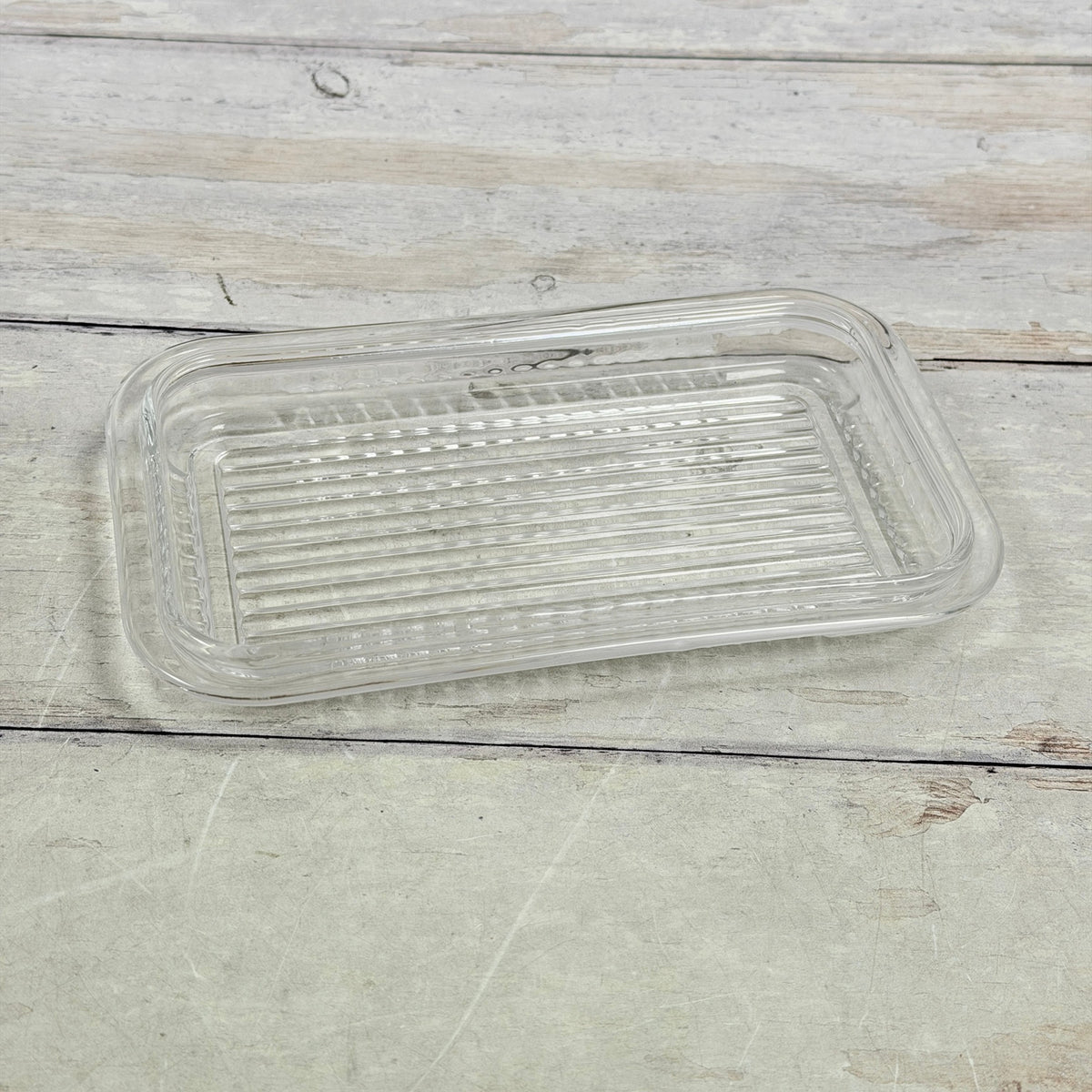 Clear glass butter dish base with ribbed tray surface and rounded corners