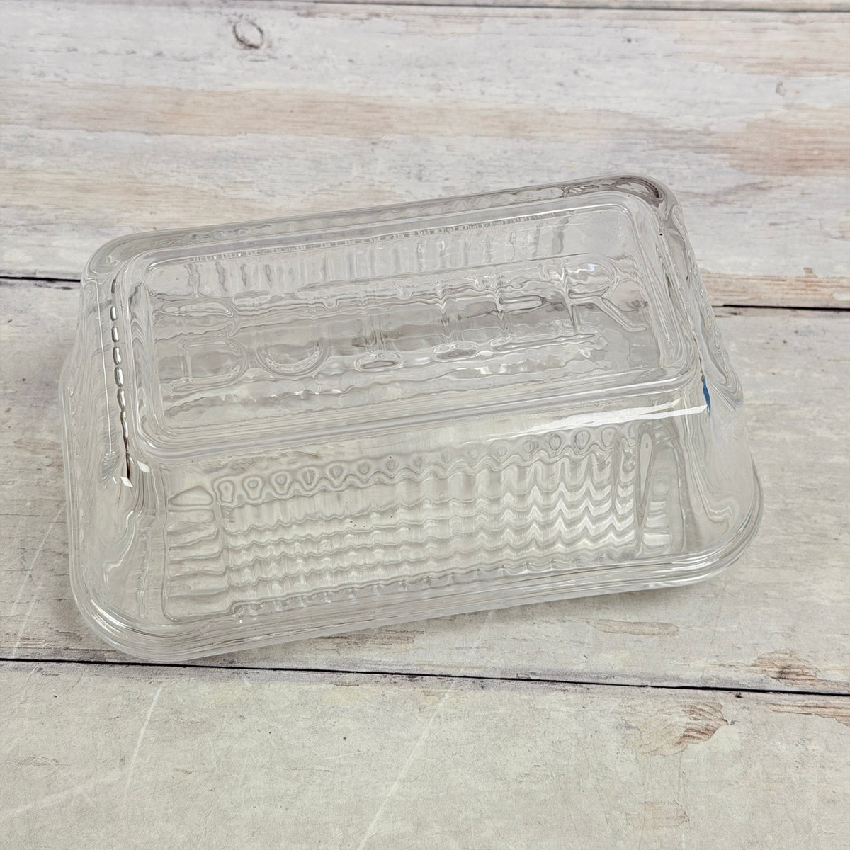 Clear glass butter dish showing embossed BUTTER lettering across the lid