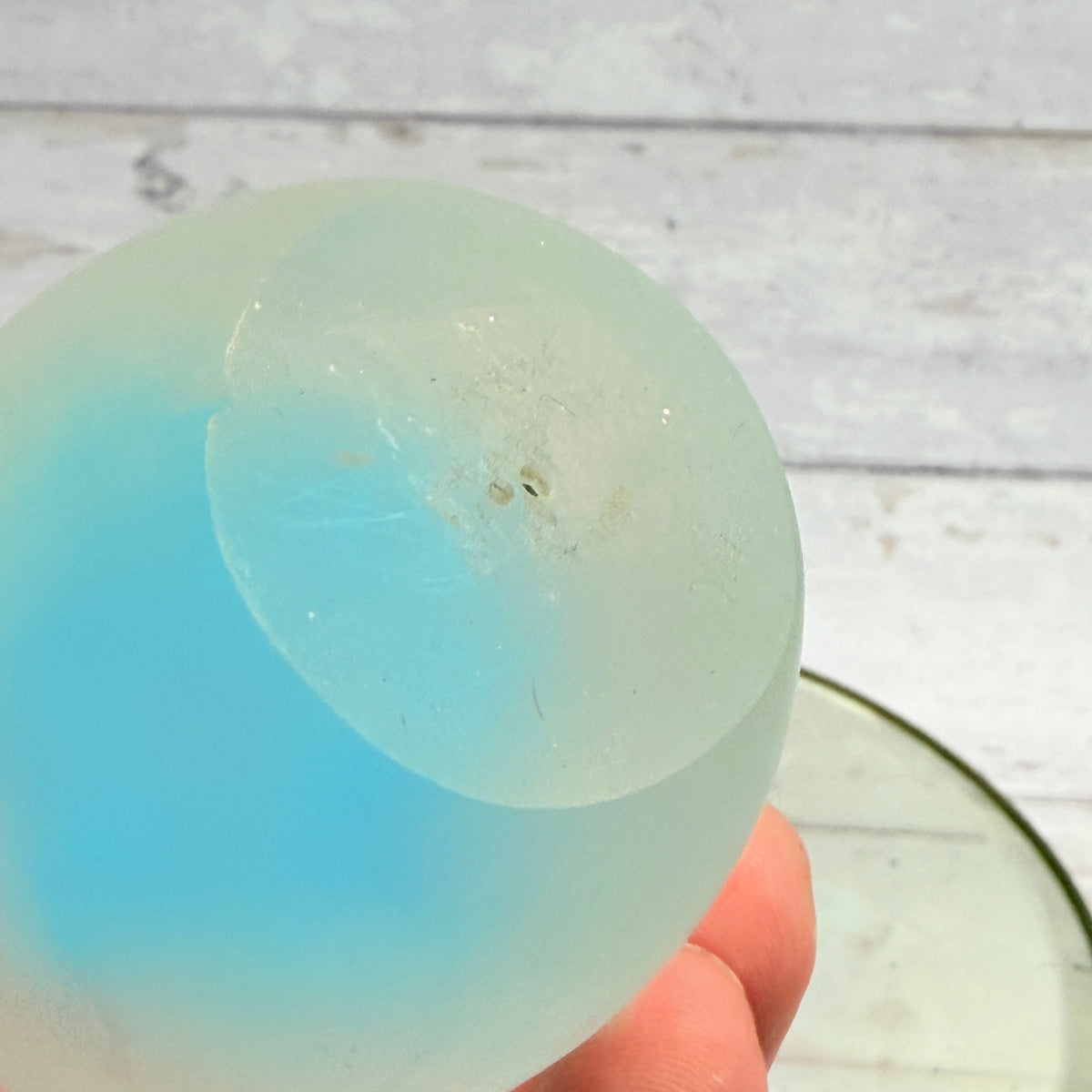 Underside of glass paperweight showing surface marks and small pits