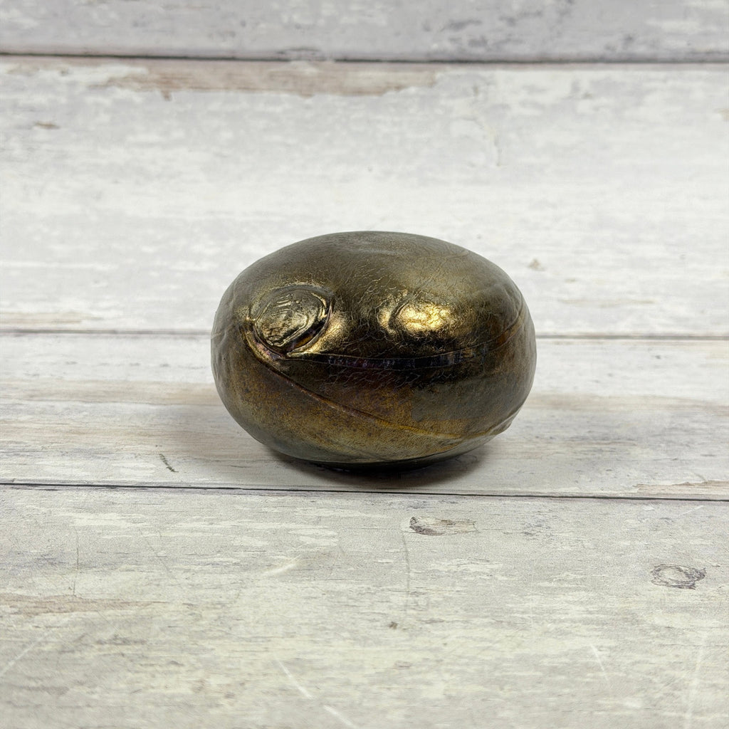 Boda Bertil Vallien iridescent glass paperweight with bronze-gold finish and trailing circular decoration, side view