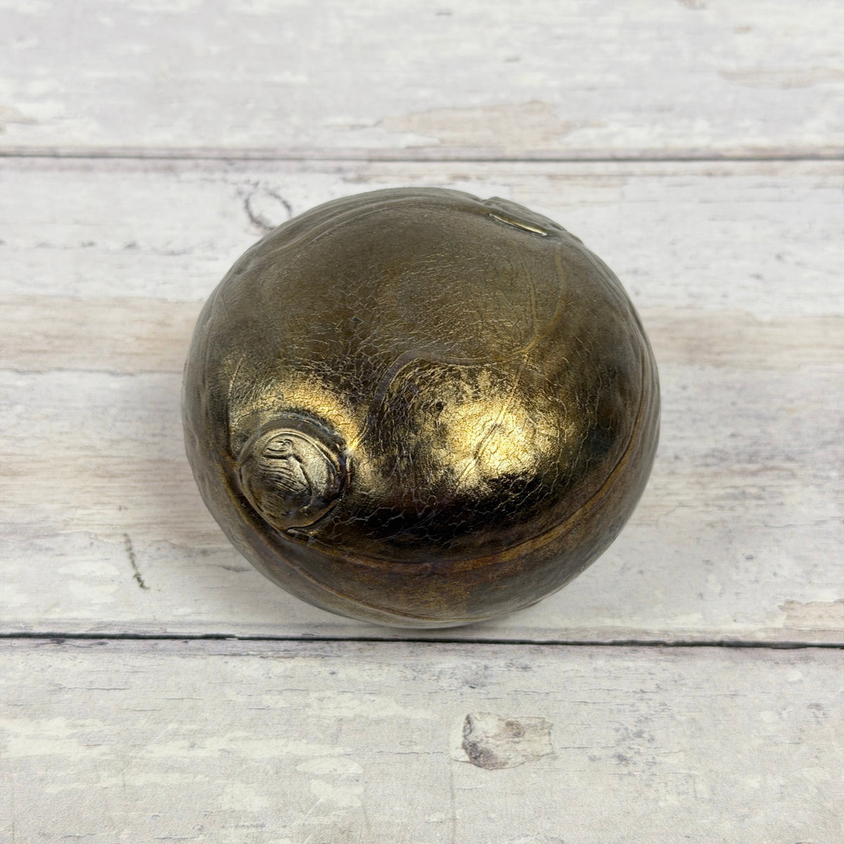 Boda Bertil Vallien iridescent glass paperweight showing rounded form and bronze-gold surface decoration