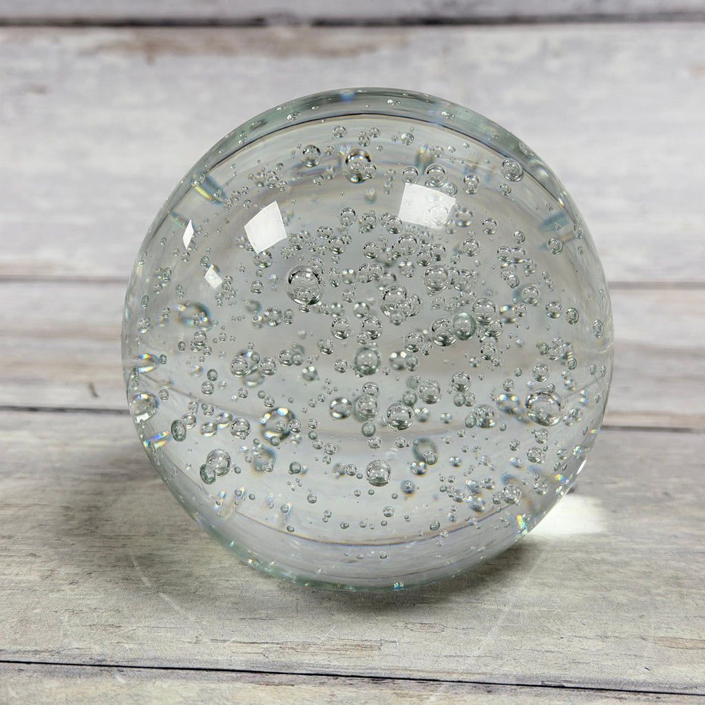 Clear round bubble glass paperweight with suspended air bubbles, front view