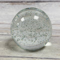 Clear round bubble glass paperweight with suspended air bubbles, front view