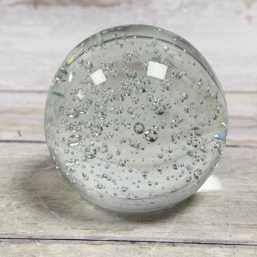 Clear bubble art glass paperweight showing rounded form and varied internal bubbles