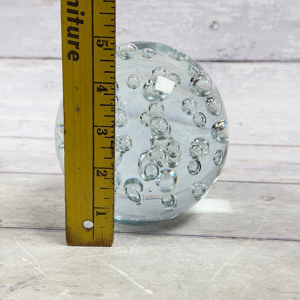 Large clear bubble glass paperweight beside ruler showing approximately 5 inch height
