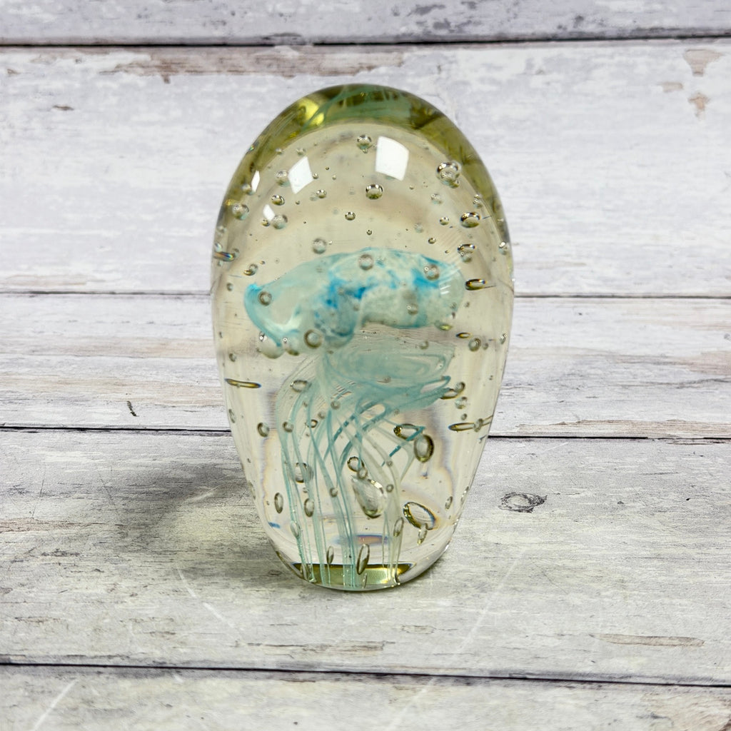 Blue jellyfish art glass paperweight with suspended bubbles in a clear oval form