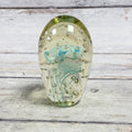 Blue jellyfish art glass paperweight with suspended bubbles in a clear oval form