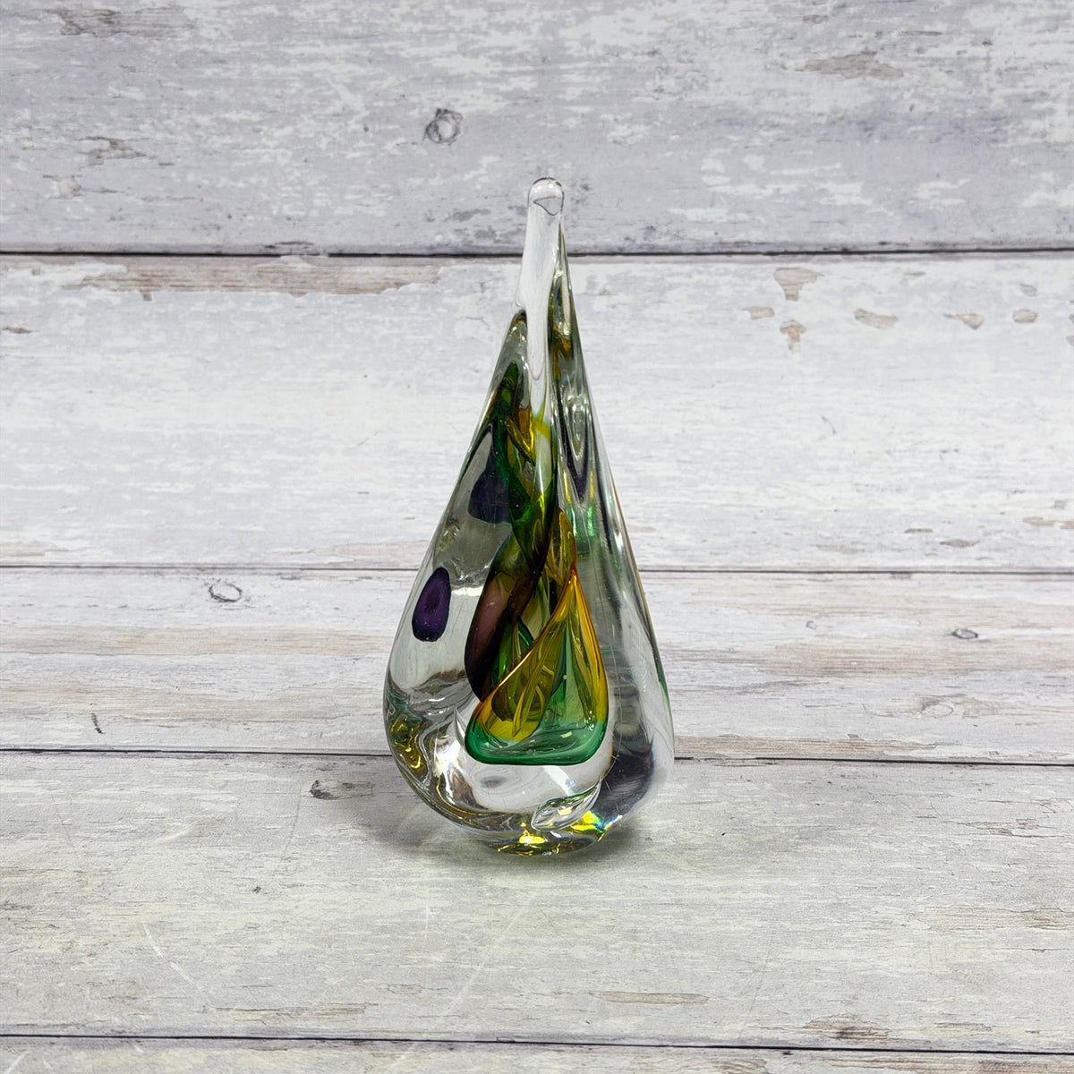 Green, yellow and purple ribbon crystal paperweight in an elongated teardrop shape