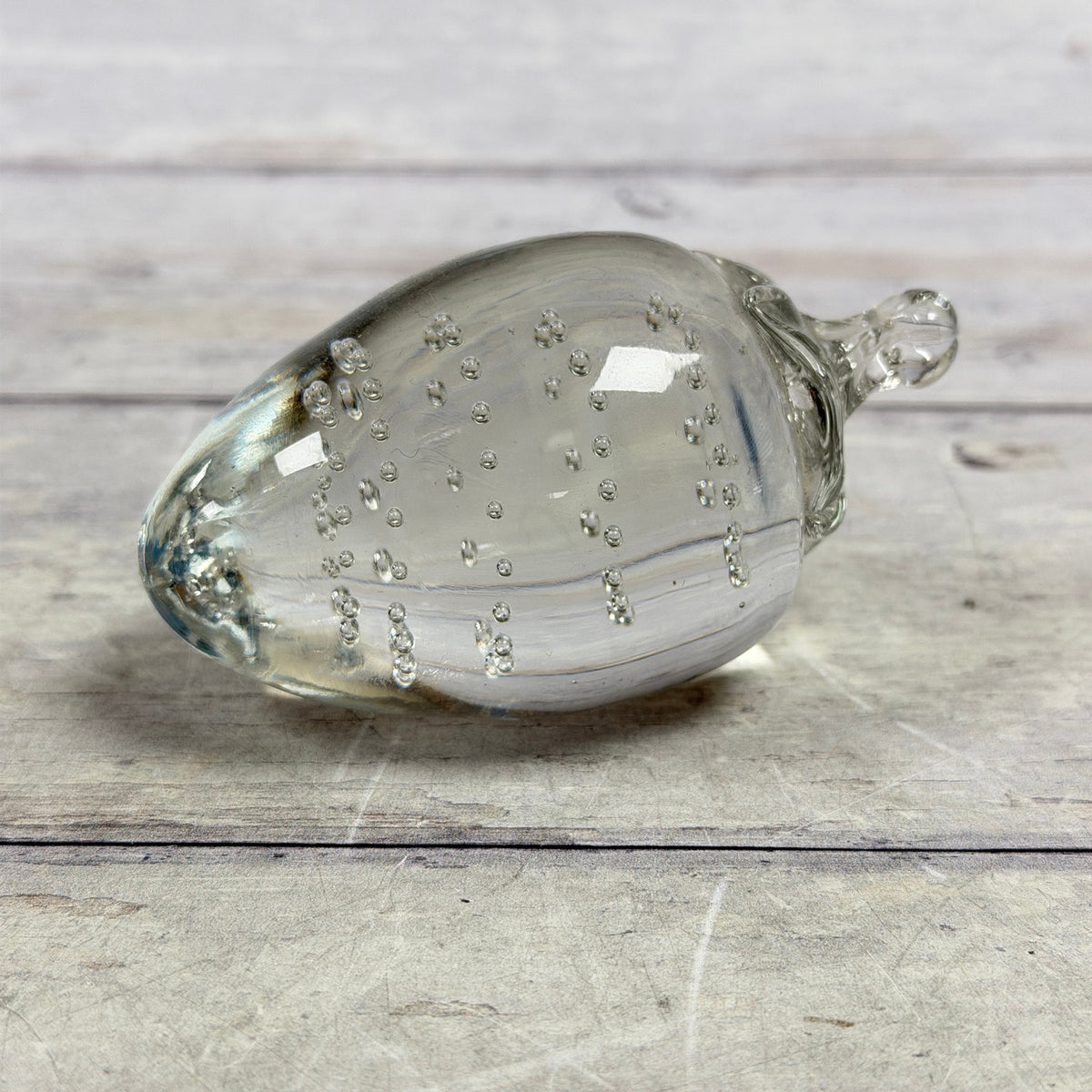 Clear strawberry-shaped glass paperweight with controlled bubbles