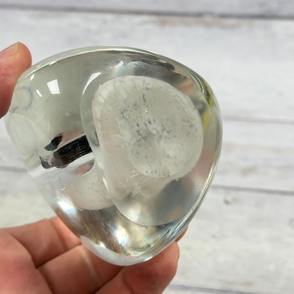 Unmarked oval base of penguin glass paperweight showing surface wear