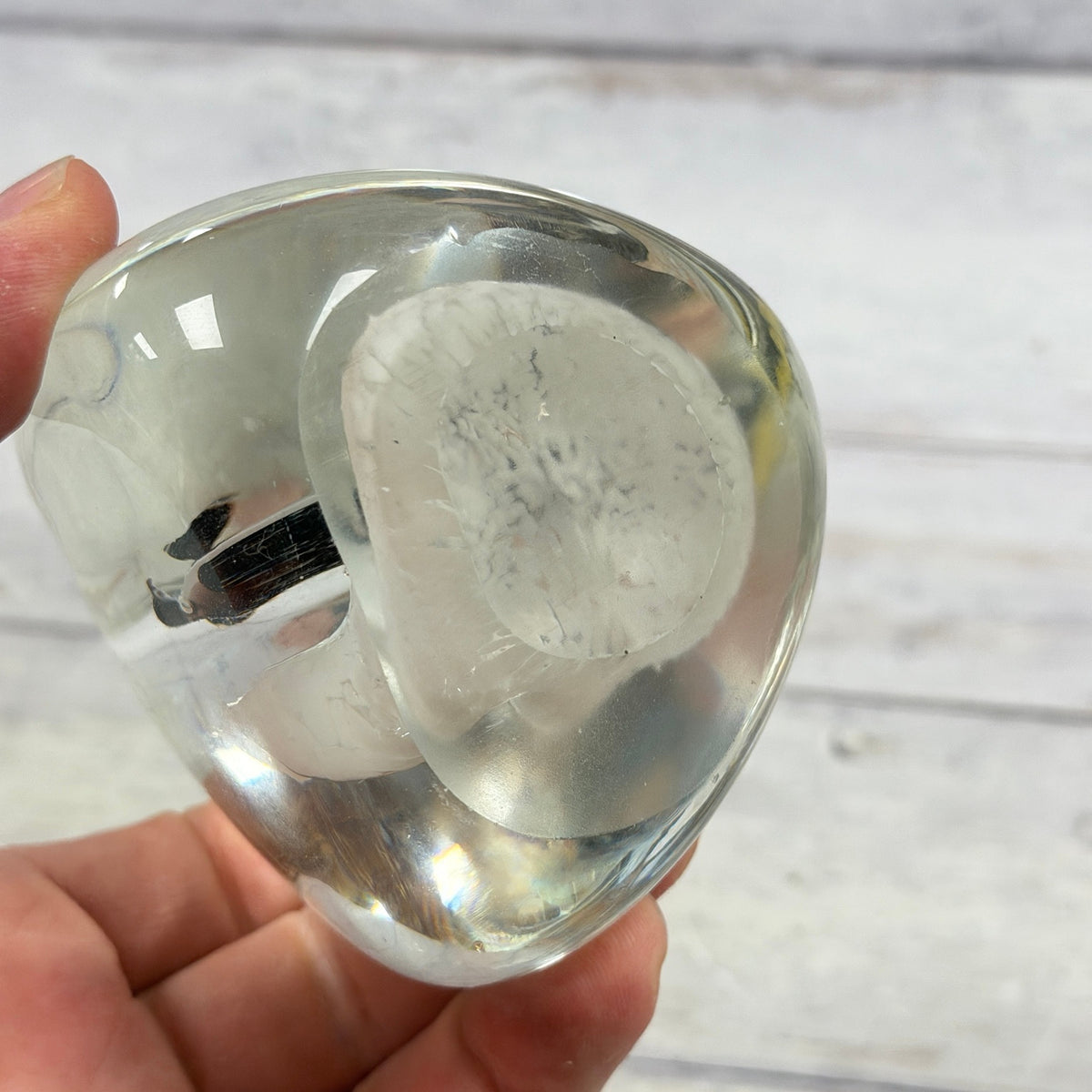Unmarked oval base of penguin glass paperweight showing surface wear