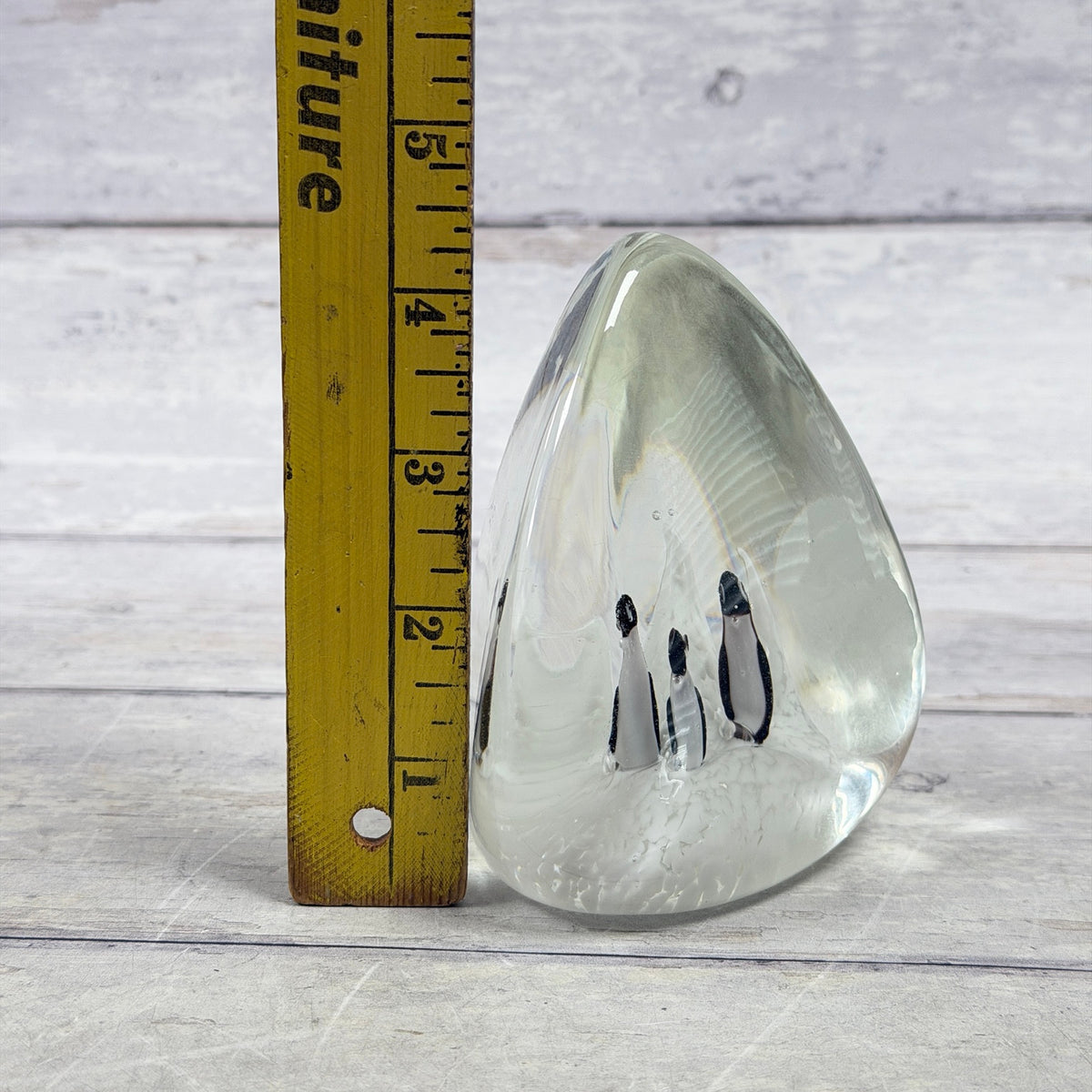 Penguin scene glass paperweight beside a ruler showing approximate four-and-a-half-inch height