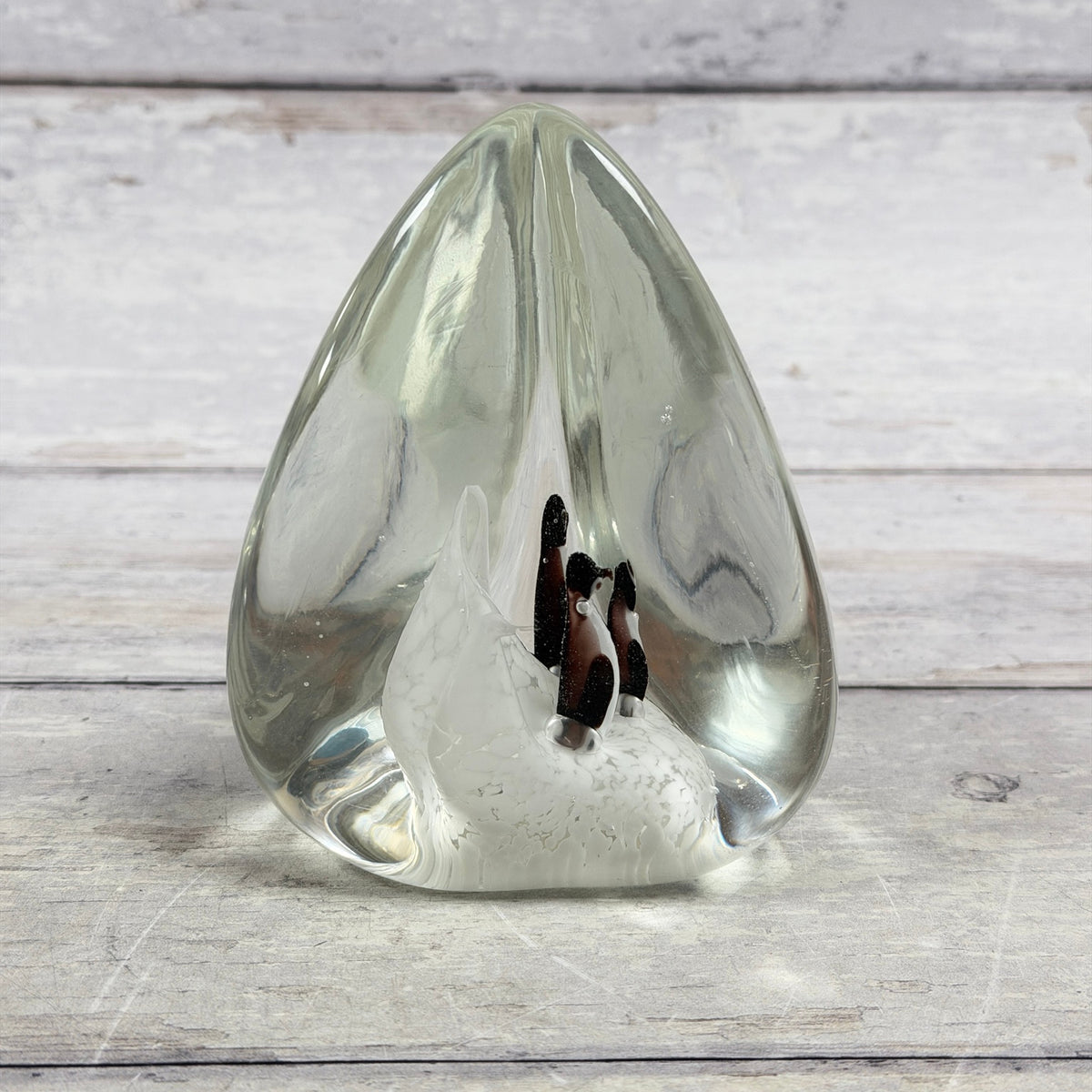 Reverse view of clear penguin scene glass paperweight