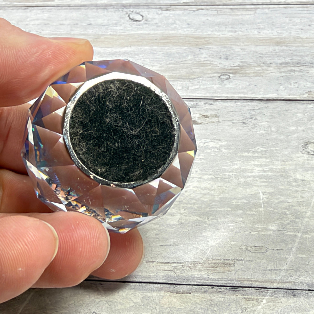Underside showing black felt base with lint and visible wear around the reflective edge