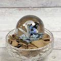 Blue, white and black floral glass paperweight with a central bubble; display bowl not included