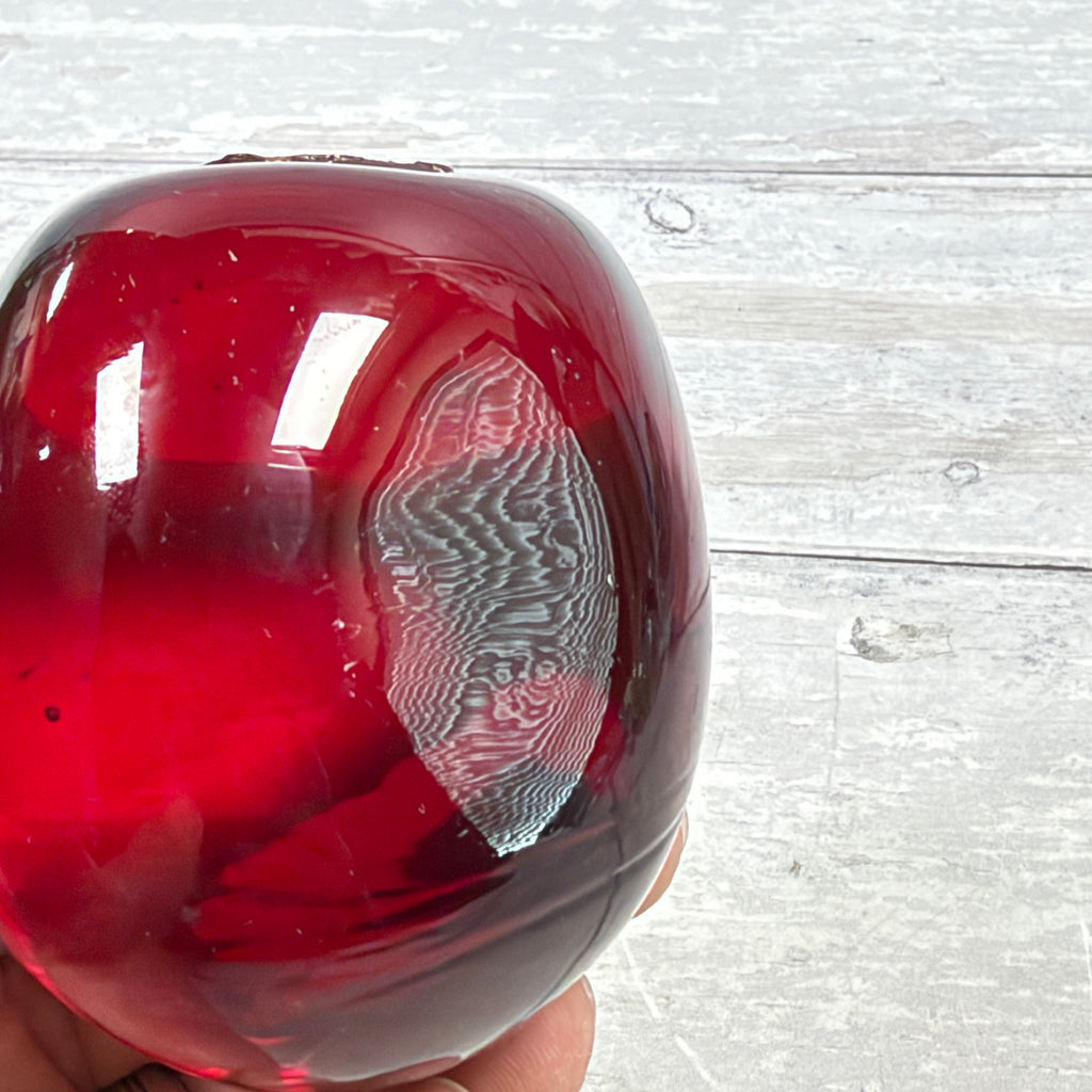 Ruby Red and Dark Swirl Oval Glass Paperweight, close-up of surface or underside