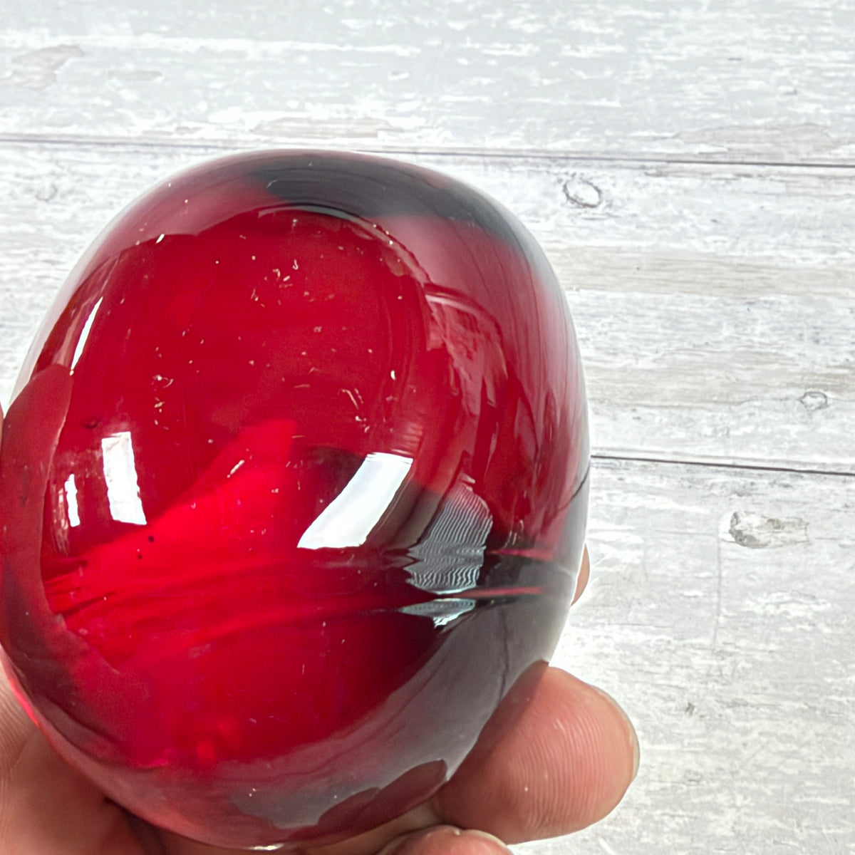Ruby Red and Dark Swirl Oval Glass Paperweight, close-up of surface or underside