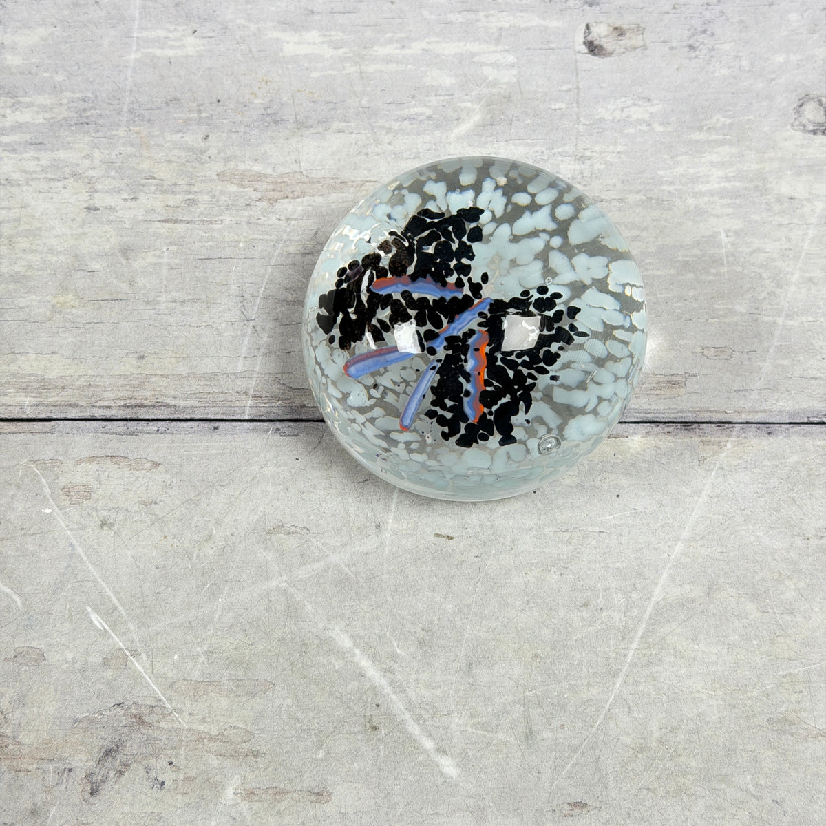 Black and Pale Blue Frit Glass Paperweight with Orange-Lavender Ribbons - product view