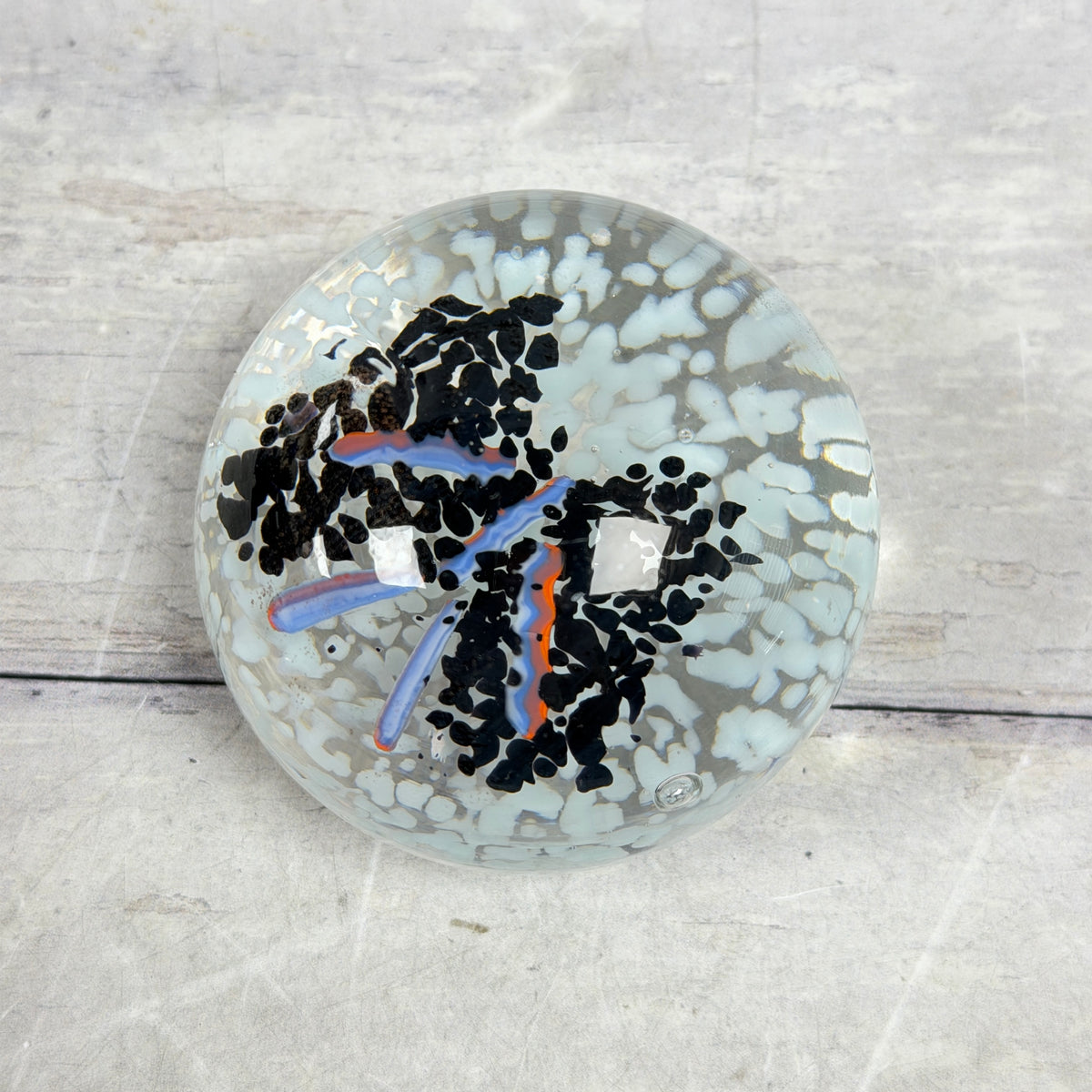 Black and Pale Blue Frit Glass Paperweight with Orange-Lavender Ribbons - product view