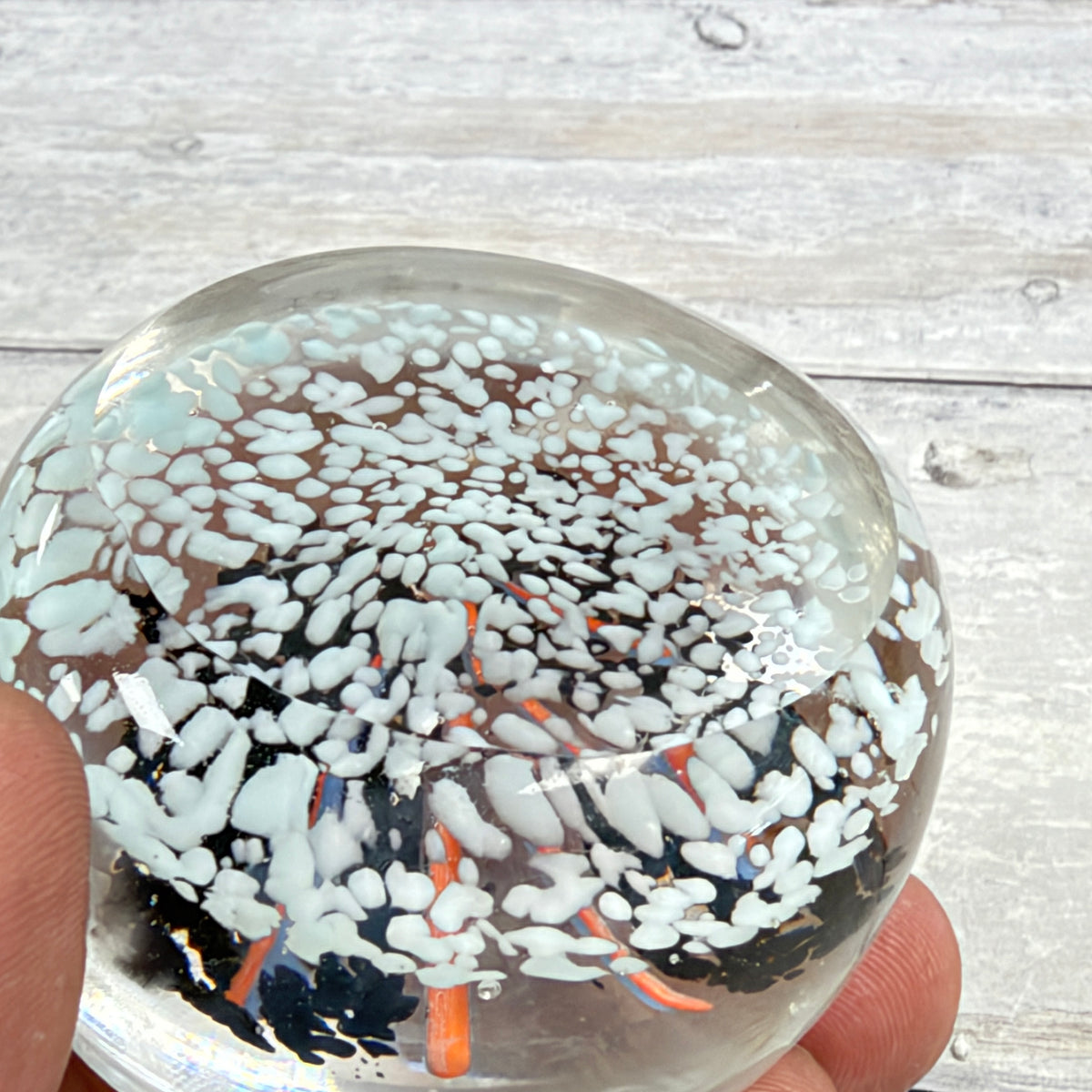 Black and Pale Blue Frit Glass Paperweight with Orange-Lavender Ribbons - underside detail