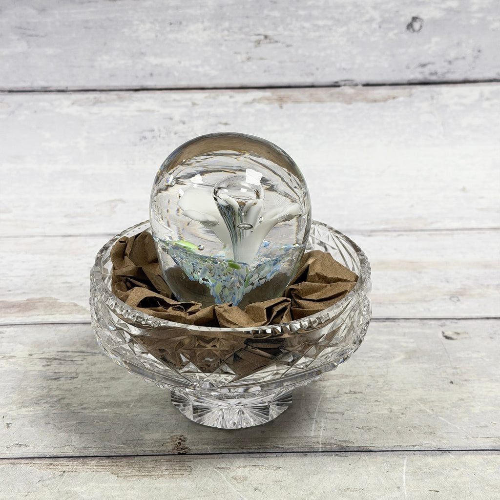 White trumpet-flower glass paperweight with blue and green frit, front view; display bowl not included